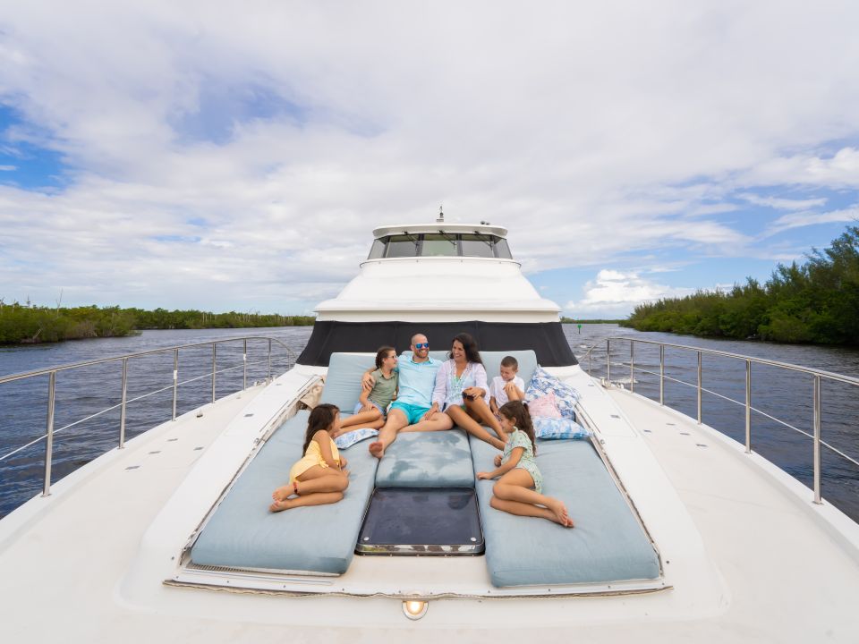 Family relaxing on the bow sun pads of a motor yacht