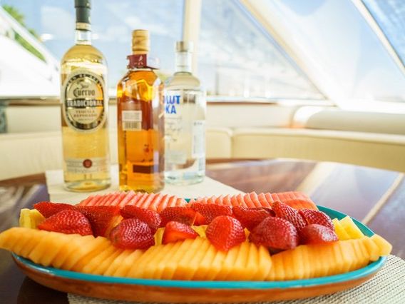 Platter of fresh fruit with bottles on a table aboard a yacht