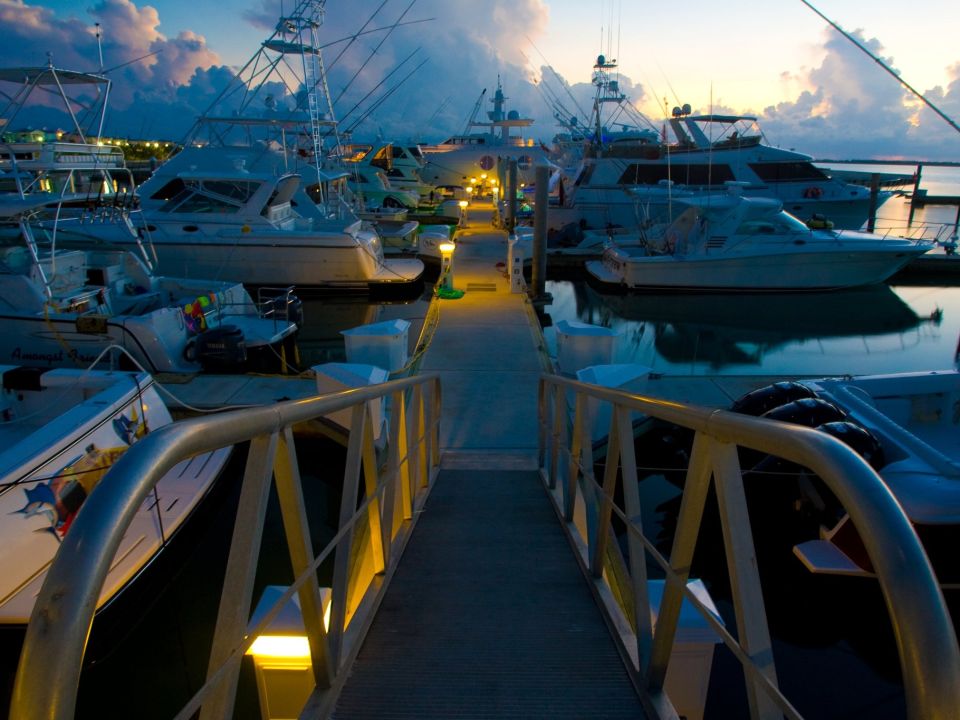 Marina walkway between berthed sportfishing yachts at dusk