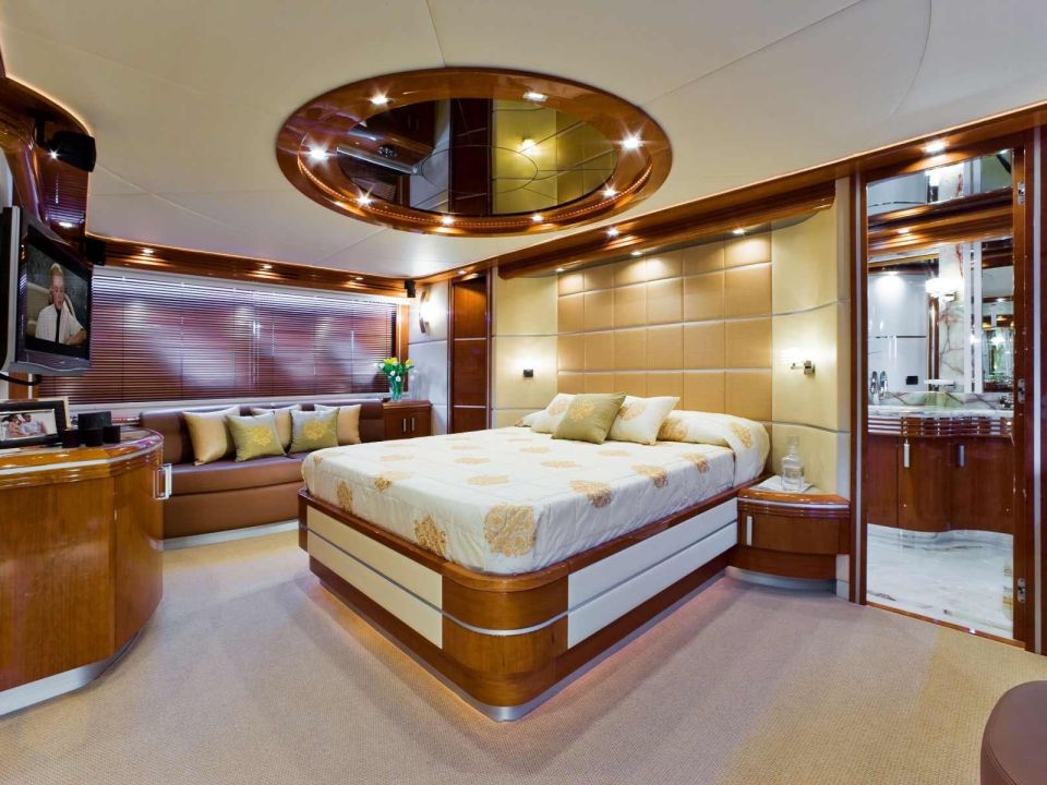 Yacht stateroom with a large bed and warm wood paneling