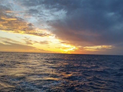 Sunset breaking through clouds over the open ocean
